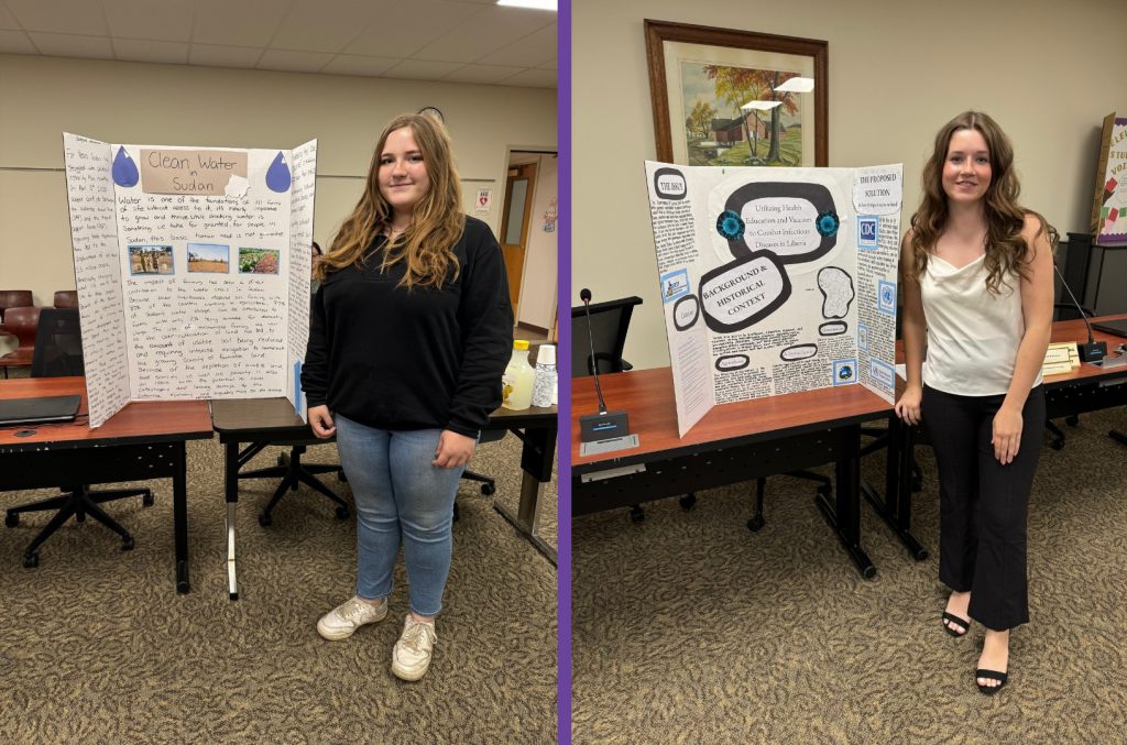 Abigail Islip and Hanley Poyer standing in front of their NYS Seal of Civic Readiness research projects.