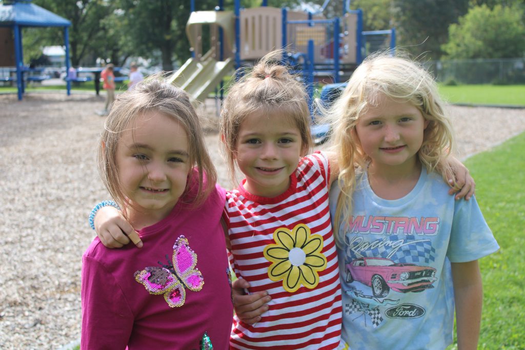 Three students stand on the playground at Memorial Park Elementary School.